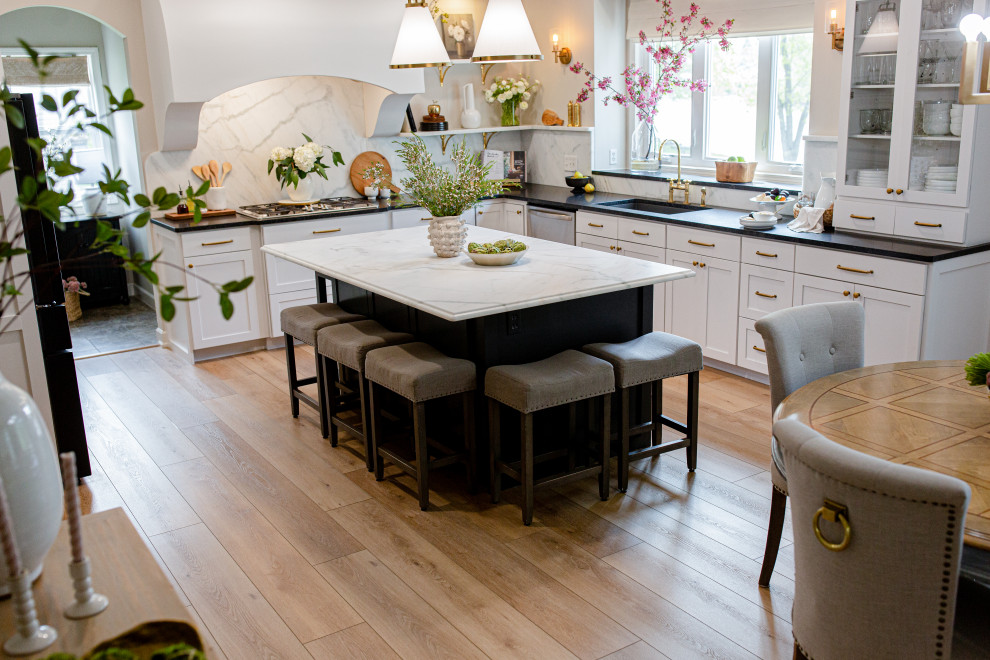 Inspiration for an expansive mediterranean u-shaped eat-in kitchen in Indianapolis with a drop-in sink, beaded inset cabinets, white cabinets, marble benchtops, white splashback, marble splashback, stainless steel appliances, vinyl floors, with island, beige floor, white benchtop and vaulted.