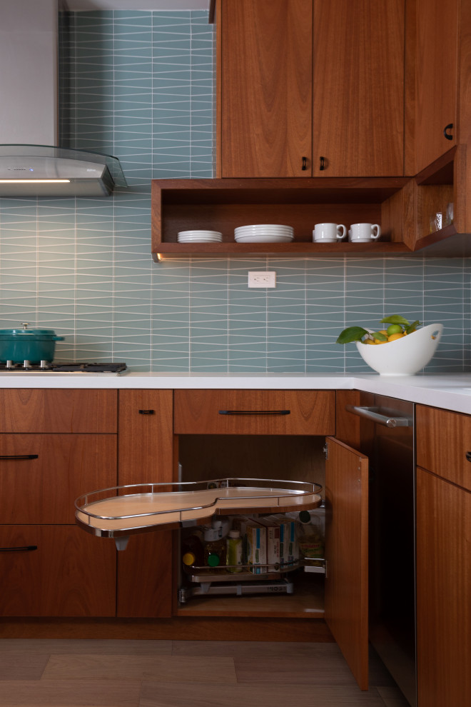 Immagine di una cucina minimalista di medie dimensioni con ante lisce, ante in legno scuro, top in quarzo composito, paraspruzzi blu, paraspruzzi con piastrelle di vetro, elettrodomestici in acciaio inossidabile, parquet chiaro e top bianco
