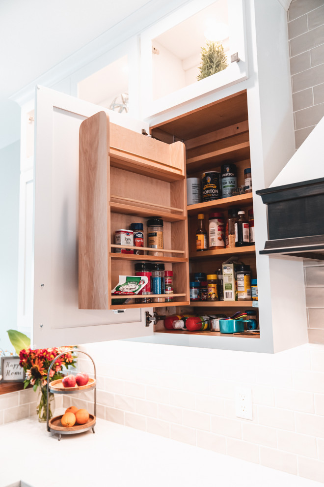 Kitchen pantry - large transitional l-shaped vinyl floor and brown floor kitchen pantry idea with an undermount sink, shaker cabinets, white cabinets, quartz countertops, gray backsplash, subway tile backsplash, stainless steel appliances, an island and white countertops