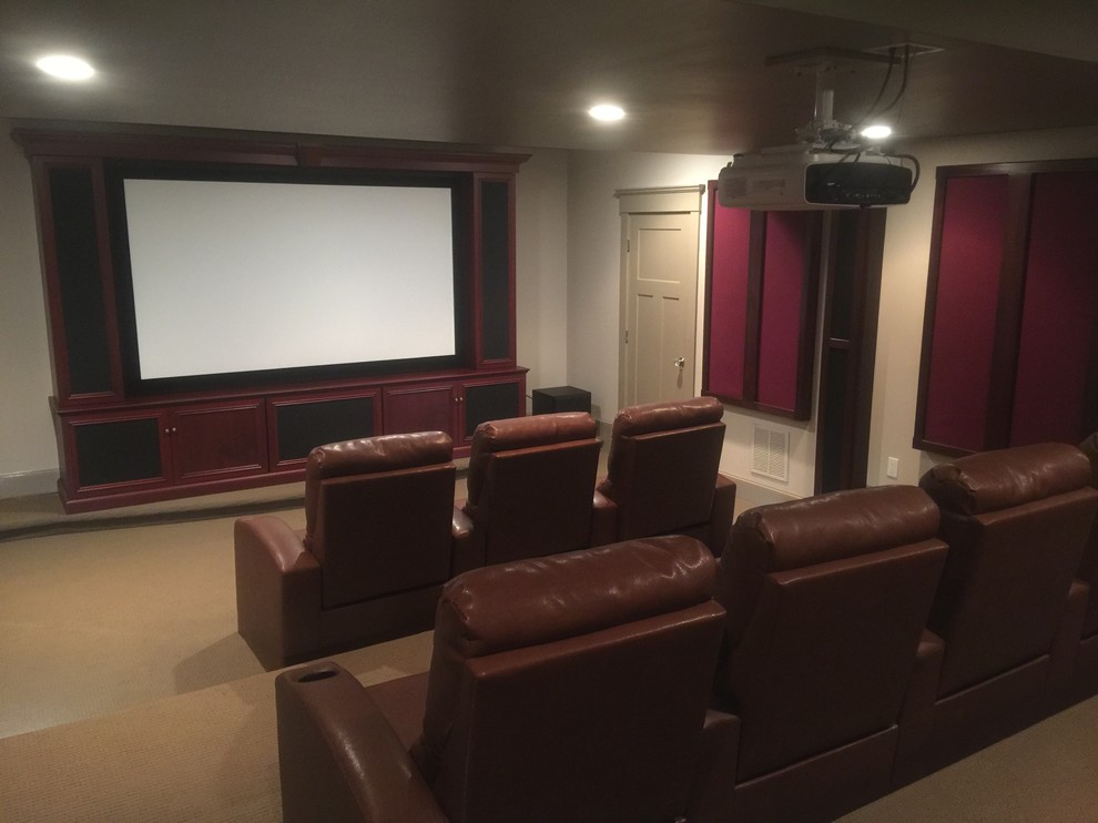 This is an example of a mid-sized traditional enclosed home theatre in Boston with beige walls, carpet and a projector screen.