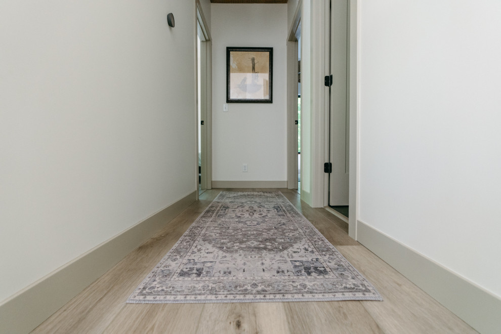 Стильный дизайн: коридор среднего размера в современном стиле с белыми стенами, полом из винила, коричневым полом и сводчатым потолком - последний тренд