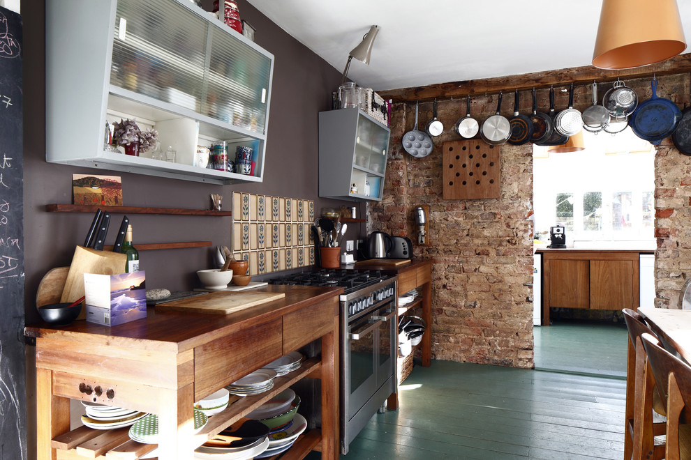 Inspiration for a mid-sized industrial single-wall eat-in kitchen in Sussex with open cabinets, medium wood cabinets, wood benchtops, beige splashback, ceramic splashback, stainless steel appliances, painted wood floors, no island and green floor.