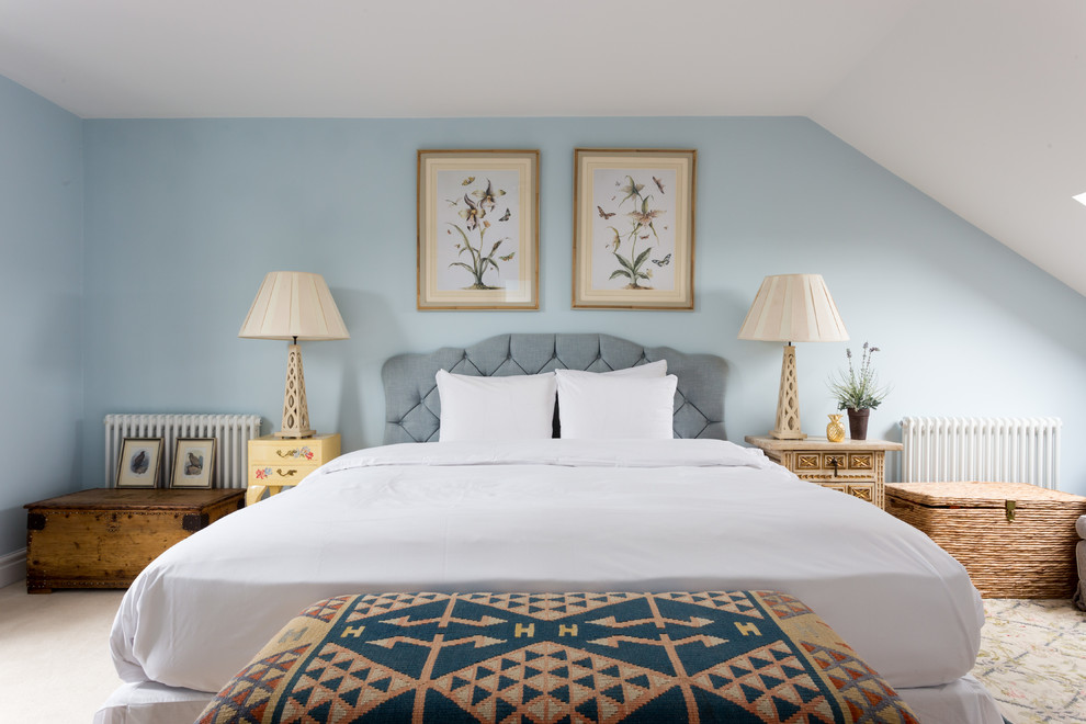 This is an example of a mid-sized traditional bedroom in London with blue walls, carpet and beige floor.