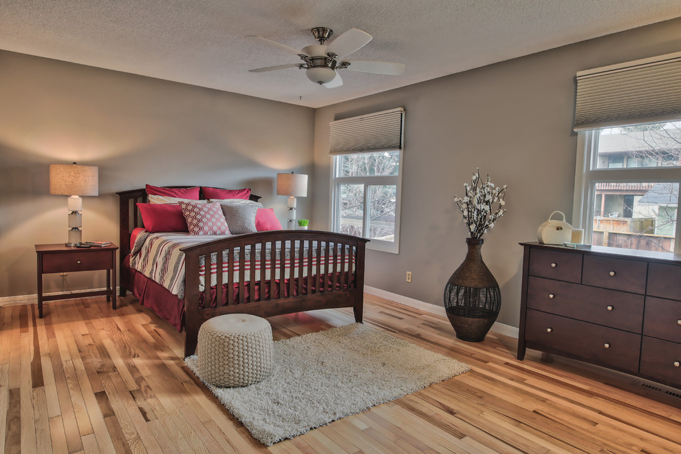 Large transitional master bedroom in Calgary with grey walls and medium hardwood floors.