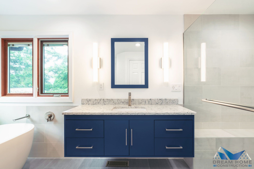 This is an example of a large modern master bathroom in Seattle with flat-panel cabinets, blue cabinets, a curbless shower, gray tile, a shower seat, a single vanity and a floating vanity.