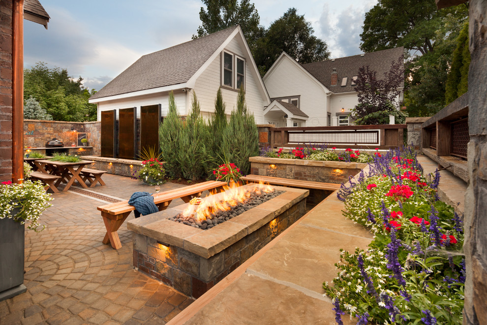Inspiration for a mid-sized country backyard patio in Denver with a fire feature, brick pavers and no cover.
