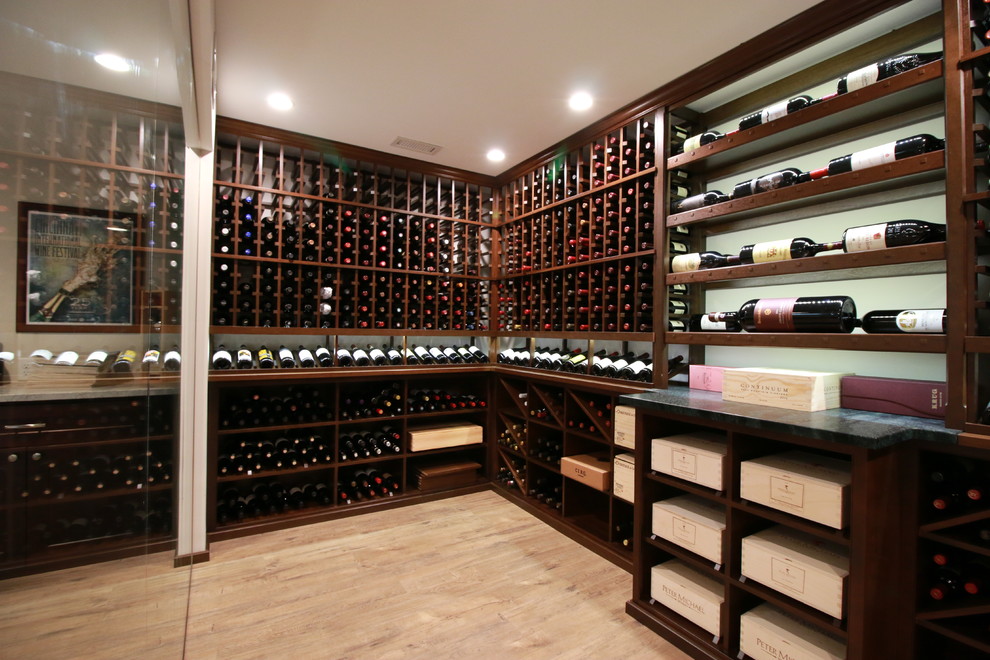 Inspiration for a mid-sized traditional wine cellar in Cincinnati with laminate floors, storage racks and brown floor.