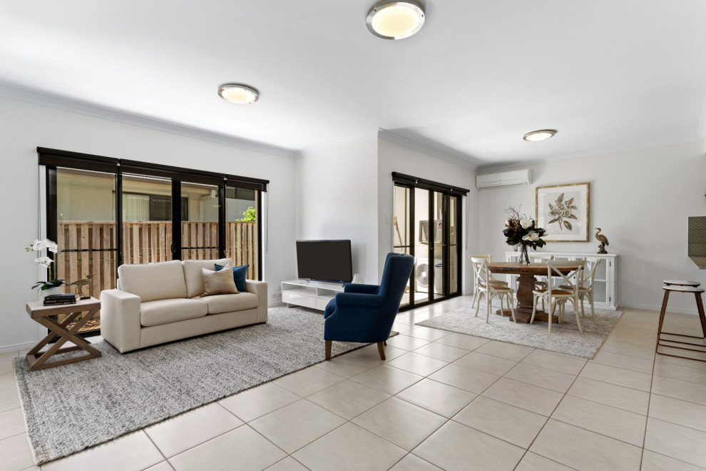 This is an example of a mid-sized contemporary open concept living room in Gold Coast - Tweed with white walls and beige floor.
