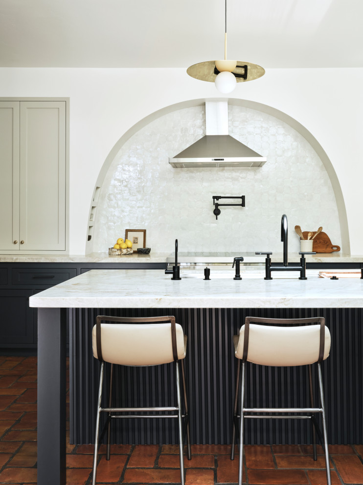 Идея дизайна: кухня среднего размера в стиле неоклассика (современная классика) с синими фасадами, белым фартуком, черной техникой и полом из терракотовой плитки