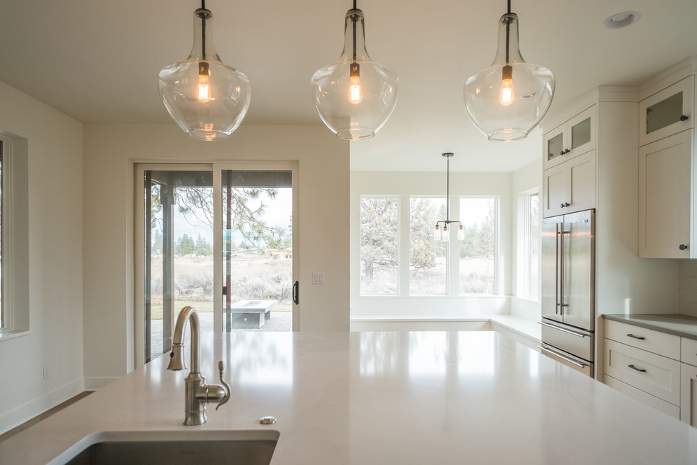 Example of a mid-sized transitional l-shaped medium tone wood floor eat-in kitchen design with an undermount sink, shaker cabinets, medium tone wood cabinets, quartz countertops, white backsplash, subway tile backsplash, stainless steel appliances and an island