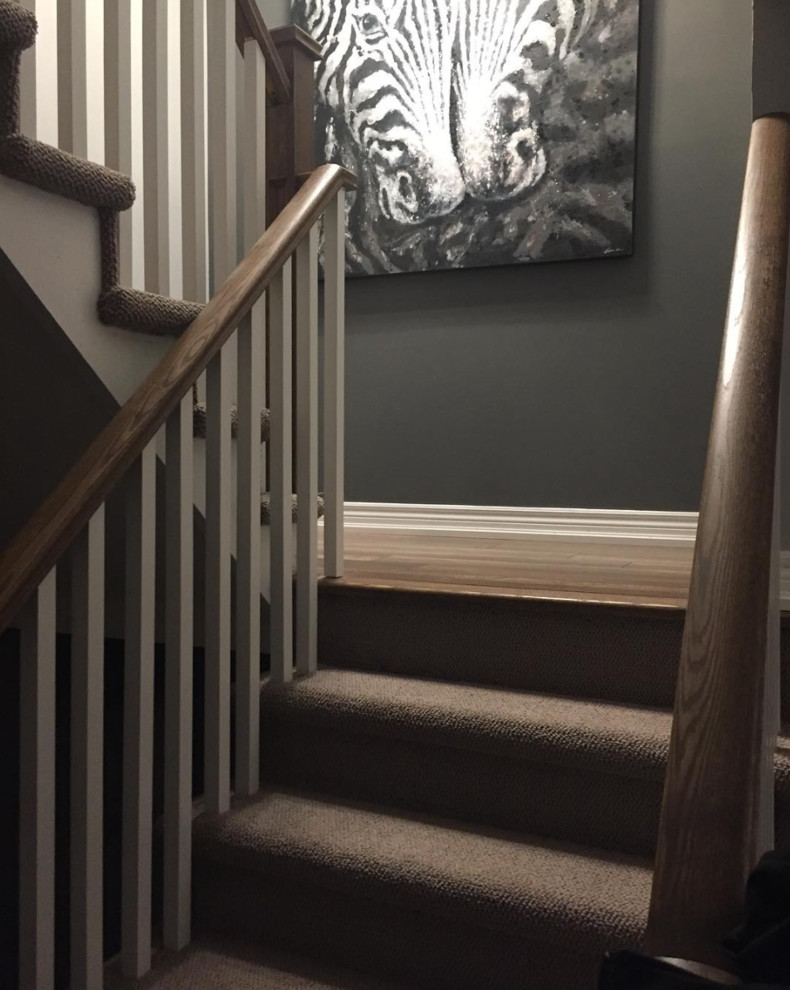 Transitional carpeted u-shaped staircase in Toronto with carpet risers.
