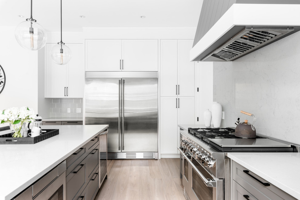Large transitional u-shaped medium tone wood floor and brown floor open concept kitchen photo in Vancouver with shaker cabinets, gray cabinets, quartz countertops, gray backsplash, stone slab backsplash, stainless steel appliances, an island and gray countertops