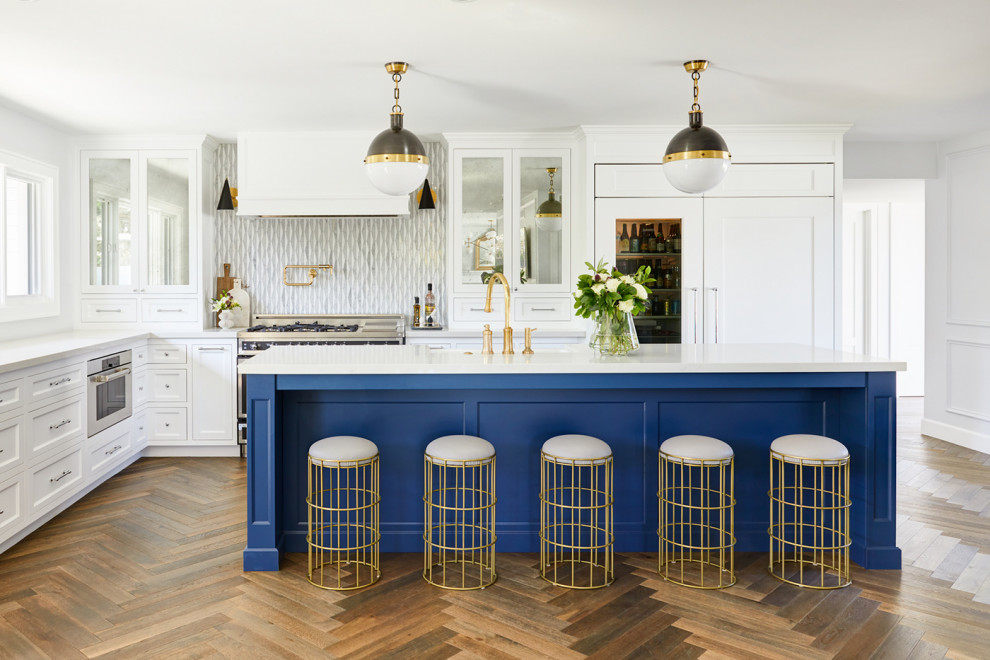 Kitchen - transitional l-shaped dark wood floor and brown floor kitchen idea in Phoenix with a farmhouse sink, shaker cabinets, white cabinets, gray backsplash, stainless steel appliances, an island and white countertops