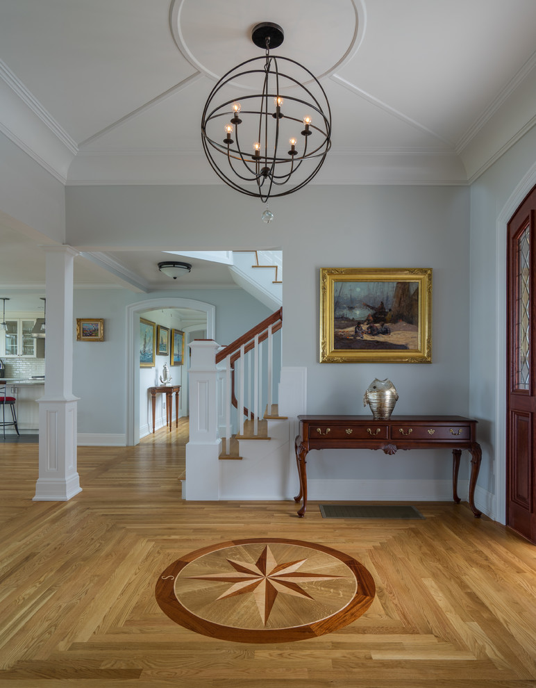 Large beach style foyer in Boston with blue walls, light hardwood floors, a single front door and a dark wood front door.