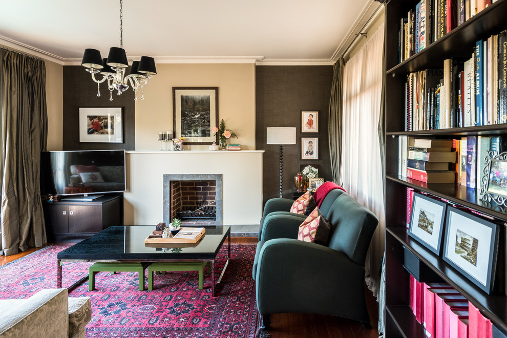 Inspiration for a mid-sized eclectic open concept living room in Melbourne with beige walls, dark hardwood floors, a standard fireplace, a stone fireplace surround, a freestanding tv and red floor.