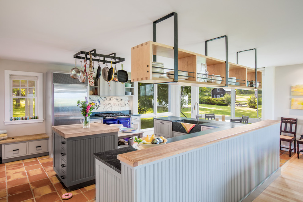 Design ideas for a large country eat-in kitchen in Burlington with a farmhouse sink, beaded inset cabinets, soapstone benchtops, white cabinets, stainless steel appliances, terra-cotta floors, multiple islands and brown floor.