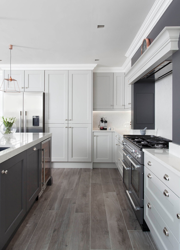 Photo of a large traditional l-shaped open plan kitchen in Other with an undermount sink, shaker cabinets, grey cabinets, quartzite benchtops, grey splashback, stone slab splashback, stainless steel appliances, porcelain floors, with island and brown floor.
