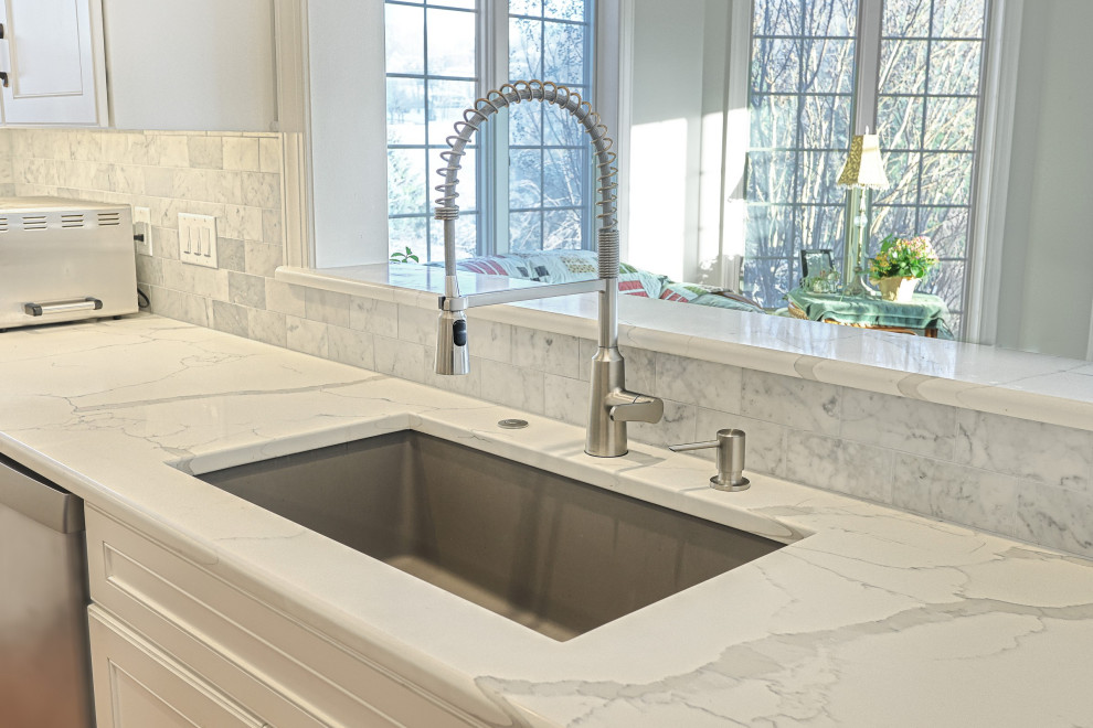 Example of a huge transitional u-shaped medium tone wood floor and brown floor eat-in kitchen design with an undermount sink, beaded inset cabinets, dark wood cabinets, quartz countertops, multicolored backsplash, marble backsplash, stainless steel appliances, an island and white countertops