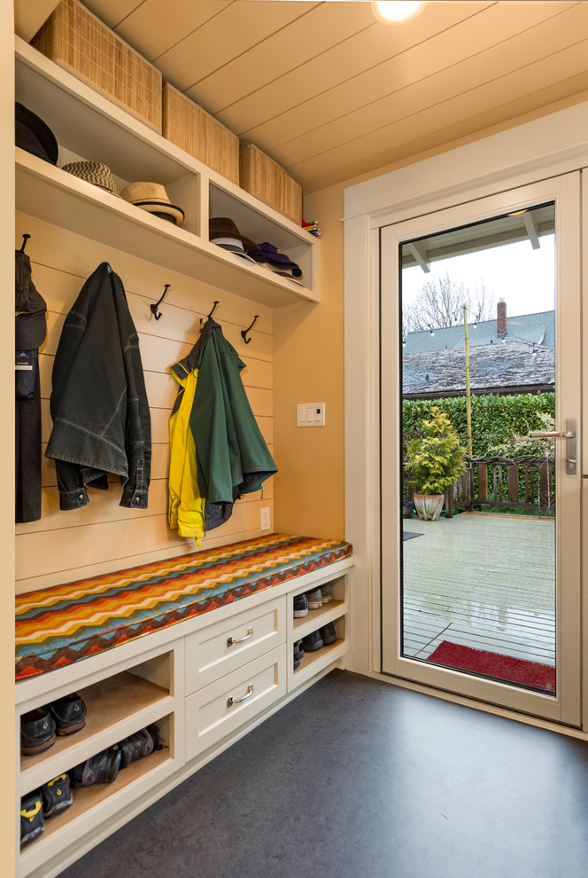 Design ideas for a small arts and crafts mudroom in Seattle with yellow walls, linoleum floors, a single front door, a glass front door and grey floor.