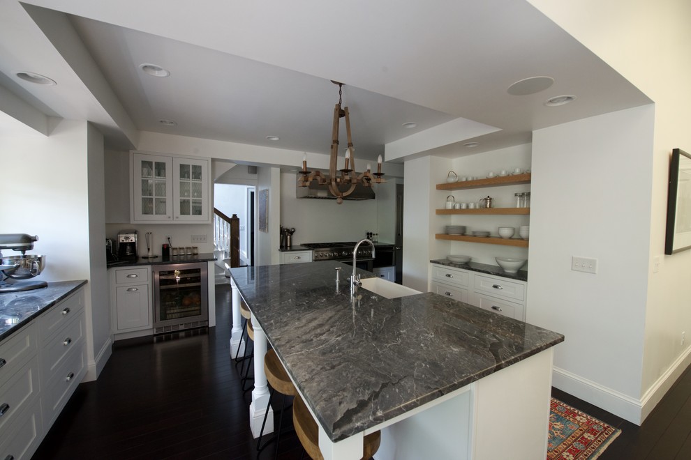 Large transitional u-shaped open plan kitchen in Denver with a farmhouse sink, beaded inset cabinets, white cabinets, marble benchtops, stainless steel appliances, bamboo floors and with island.
