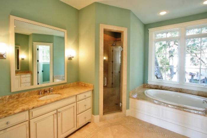 Inspiration for a large transitional master bathroom in Atlanta with raised-panel cabinets, beige cabinets, a drop-in tub, an alcove shower, beige tile, ceramic tile, green walls, ceramic floors, an undermount sink and limestone benchtops.