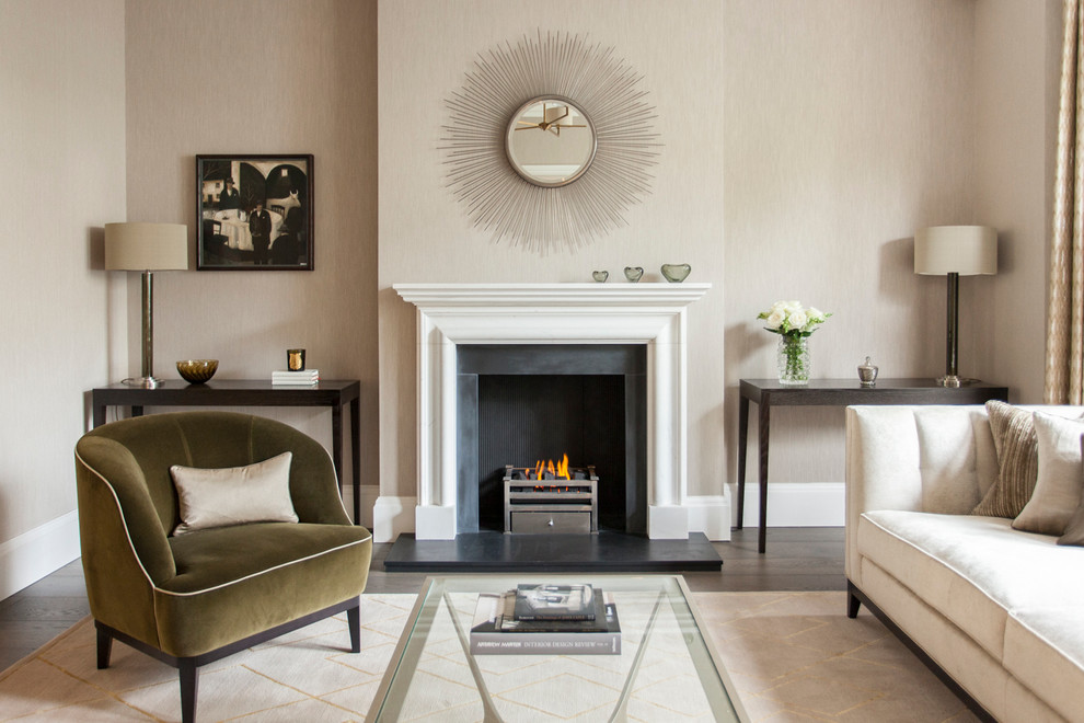 Transitional living room in London with beige walls, dark hardwood floors and a standard fireplace.
