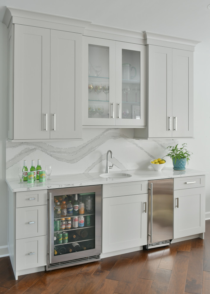 Medium sized classic home bar in Atlanta with a submerged sink, flat-panel cabinets, white cabinets, engineered stone countertops, white splashback, brown floors and white worktops.