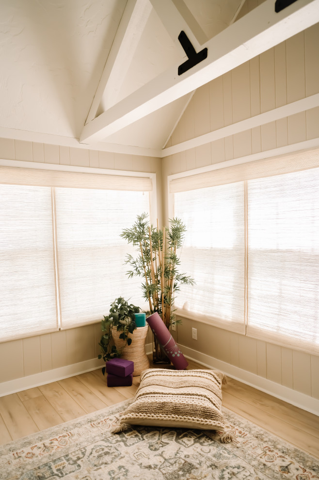 Example of a trendy medium tone wood floor, brown floor and coffered ceiling home yoga studio design in Cedar Rapids with beige walls