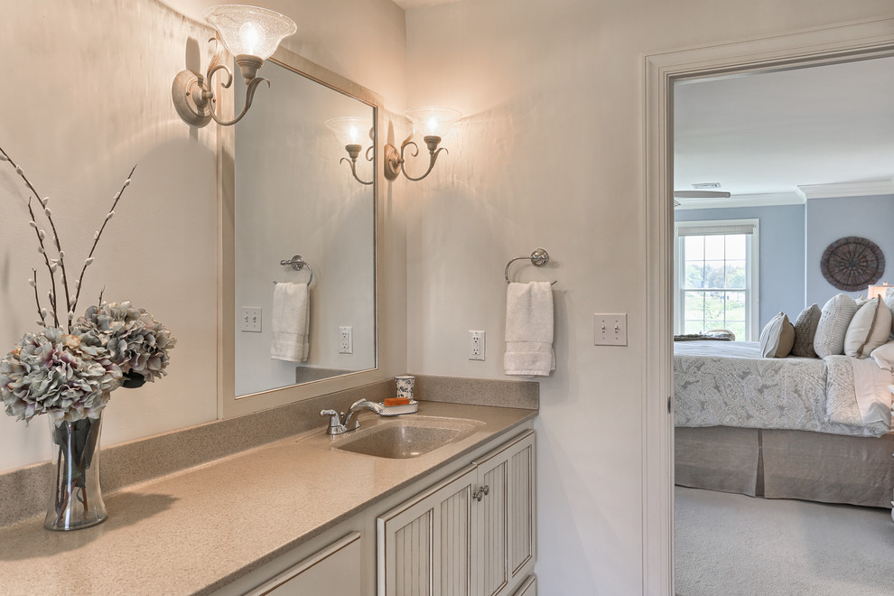 Design ideas for a traditional master bathroom in Orange County with beige cabinets, a hot tub, beige tile, porcelain tile, beige walls, an integrated sink and laminate benchtops.