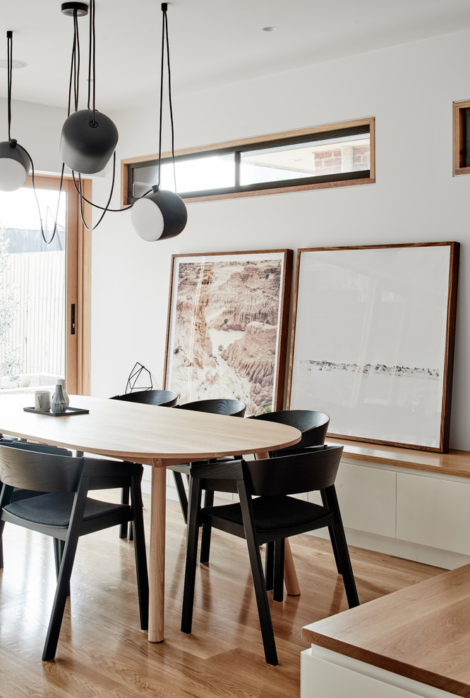 Inspiration for a modern open plan dining in Melbourne with white walls and light hardwood floors.