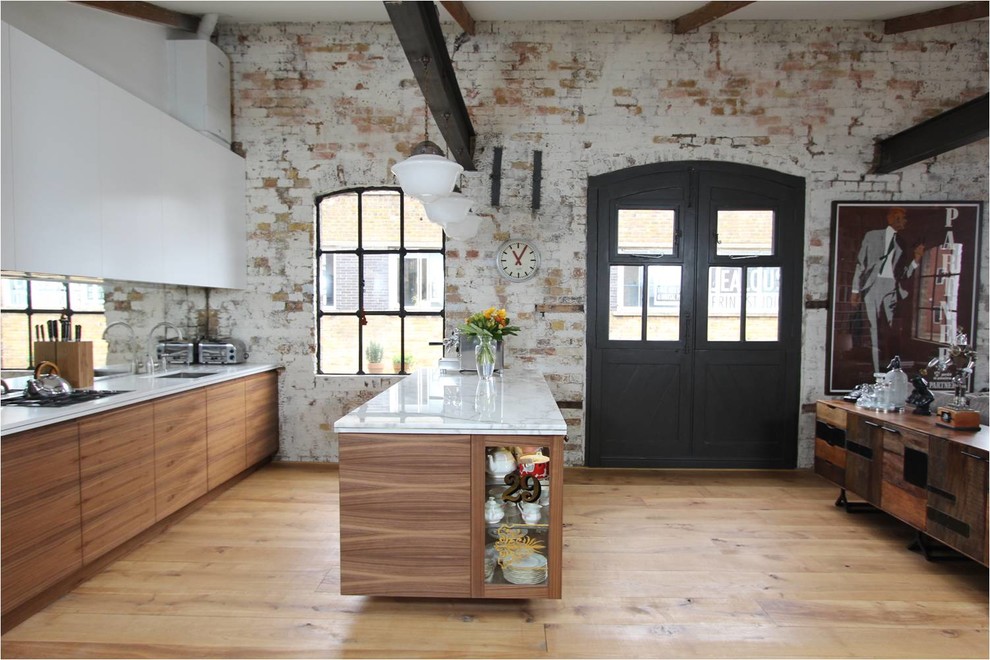Photo of a large industrial open plan kitchen in London with an undermount sink, flat-panel cabinets and medium hardwood floors.