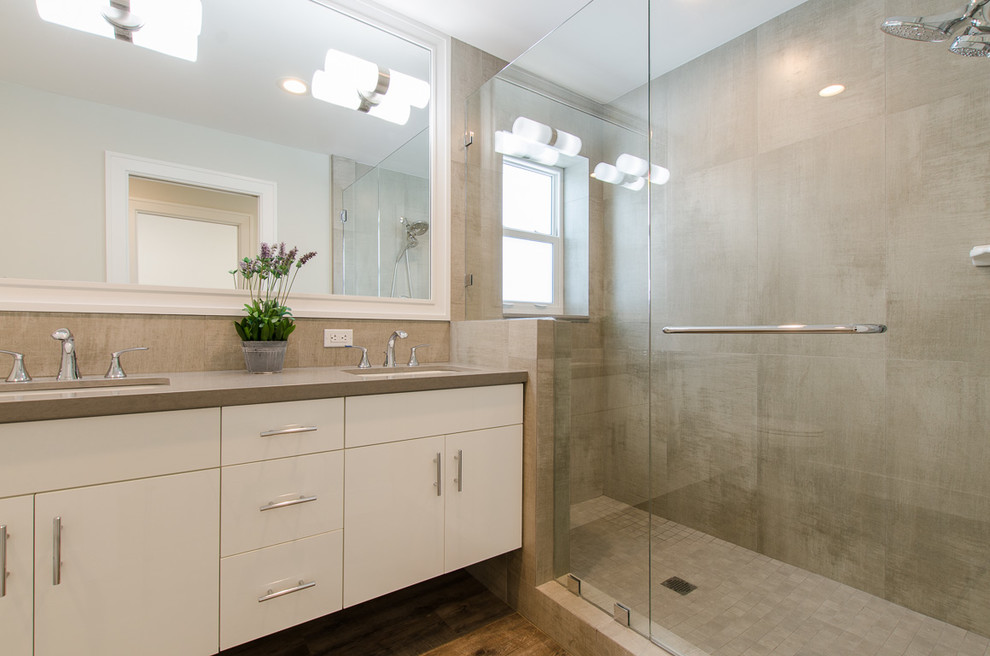 This is an example of a small contemporary 3/4 bathroom in Miami with flat-panel cabinets, white cabinets, a double shower, gray tile, ceramic tile, grey walls, vinyl floors, an undermount sink, quartzite benchtops, brown floor and a hinged shower door.