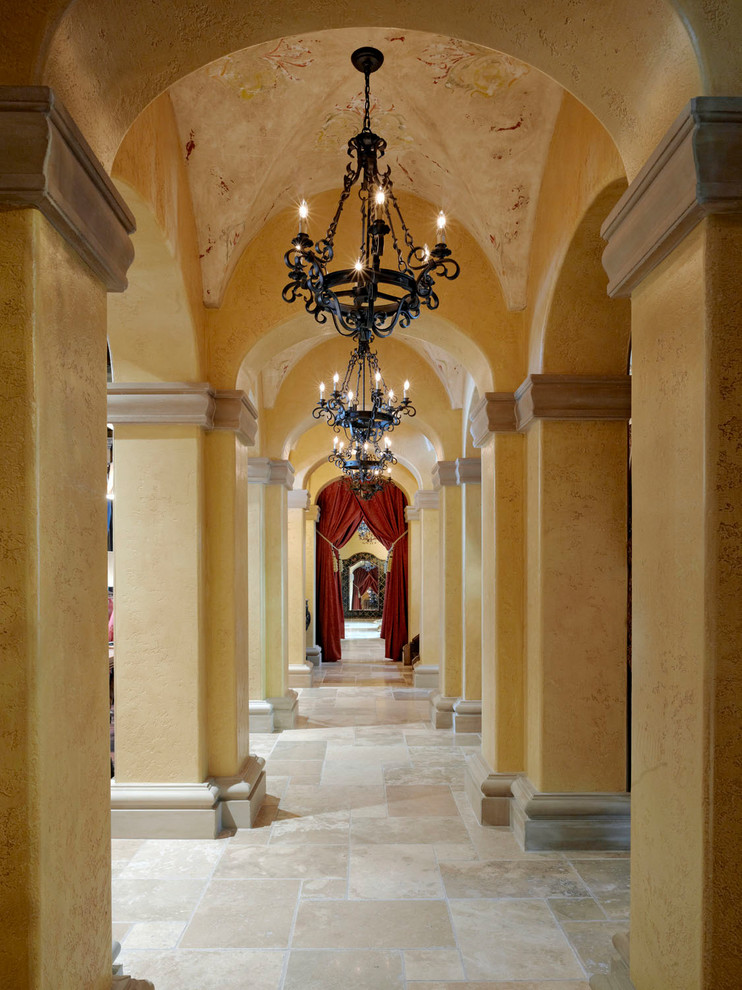 Inspiration for a large mediterranean hallway in Orlando with beige walls and travertine floors.
