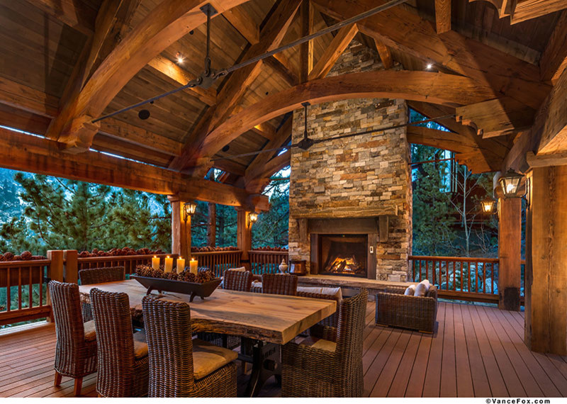 Example of a large mountain style deck design in Sacramento with a roof extension