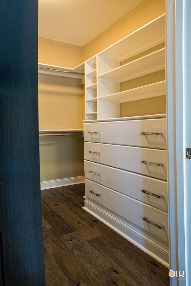 Transitional gender-neutral dark wood floor and brown floor walk-in closet photo with open cabinets and white cabinets