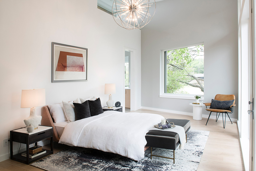 Design ideas for a modern master bedroom in Austin with light hardwood floors, brown floor and white walls.