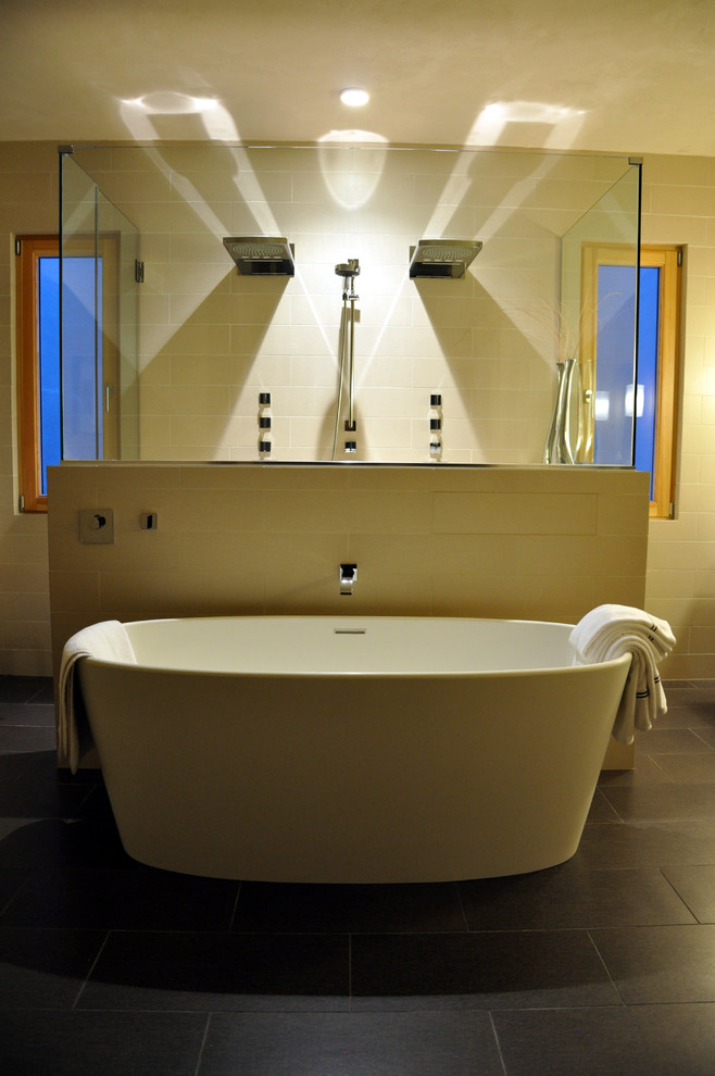 Inspiration for a large modern master bathroom in Denver with a freestanding tub, a double shower, beige tile, ceramic tile, beige walls and ceramic floors.