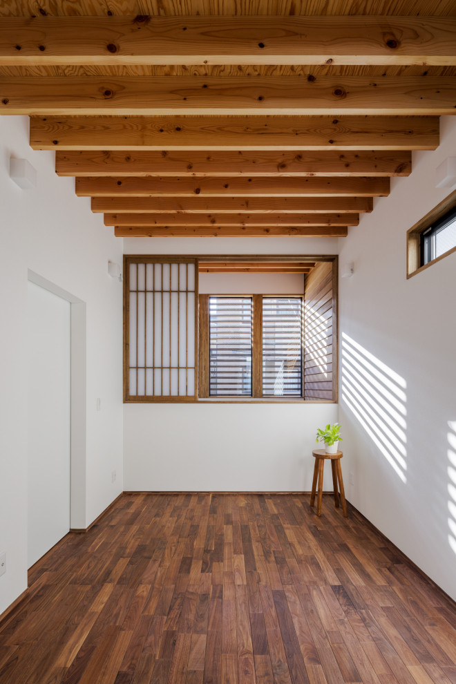 Idéer för ett litet huvudsovrum, med vita väggar, mörkt trägolv och brunt golv