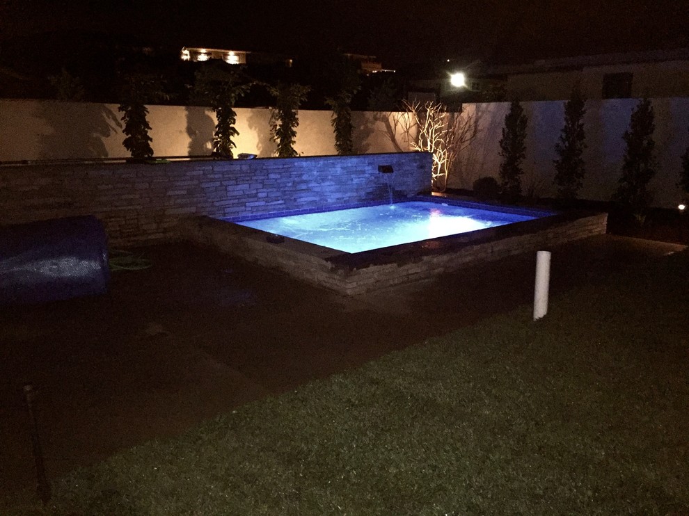 Mid-sized transitional backyard stone and rectangular lap pool fountain photo in Orange County