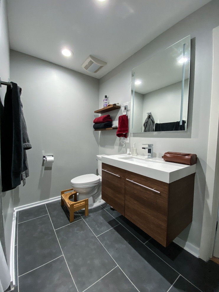 Свежая идея для дизайна: ванная комната среднего размера в стиле модернизм с плоскими фасадами, коричневыми фасадами, накладной ванной, душем в нише, раздельным унитазом, серой плиткой, керамогранитной плиткой, серыми стенами, полом из керамогранита, врезной раковиной, столешницей из искусственного кварца, серым полом, шторкой для ванной, белой столешницей, нишей, тумбой под одну раковину и подвесной тумбой - отличное фото интерьера