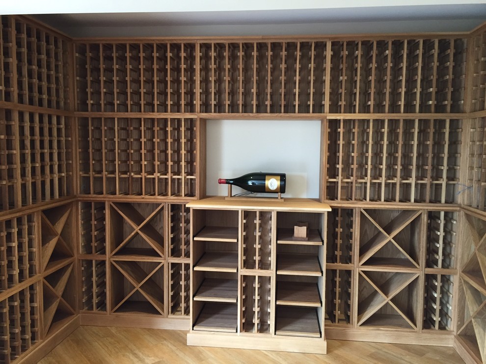This is an example of a large contemporary wine cellar in Other with storage racks, light hardwood floors and brown floor.