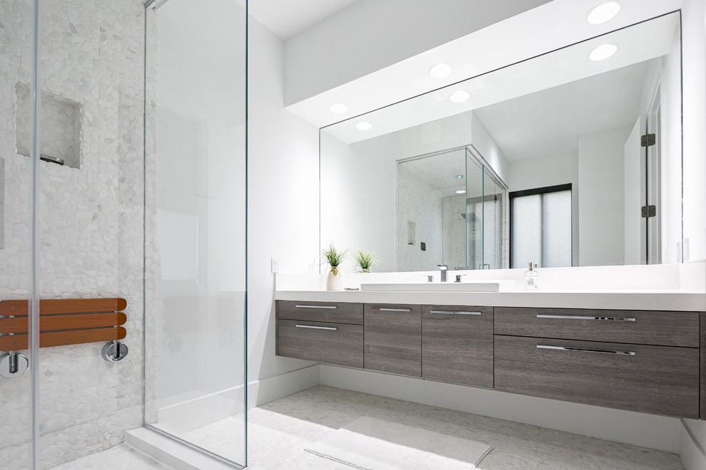 Photo of an expansive modern master bathroom in Miami with flat-panel cabinets, dark wood cabinets, quartzite benchtops, a drop-in tub, an open shower, a one-piece toilet, white tile, porcelain tile, white walls, porcelain floors and a drop-in sink.