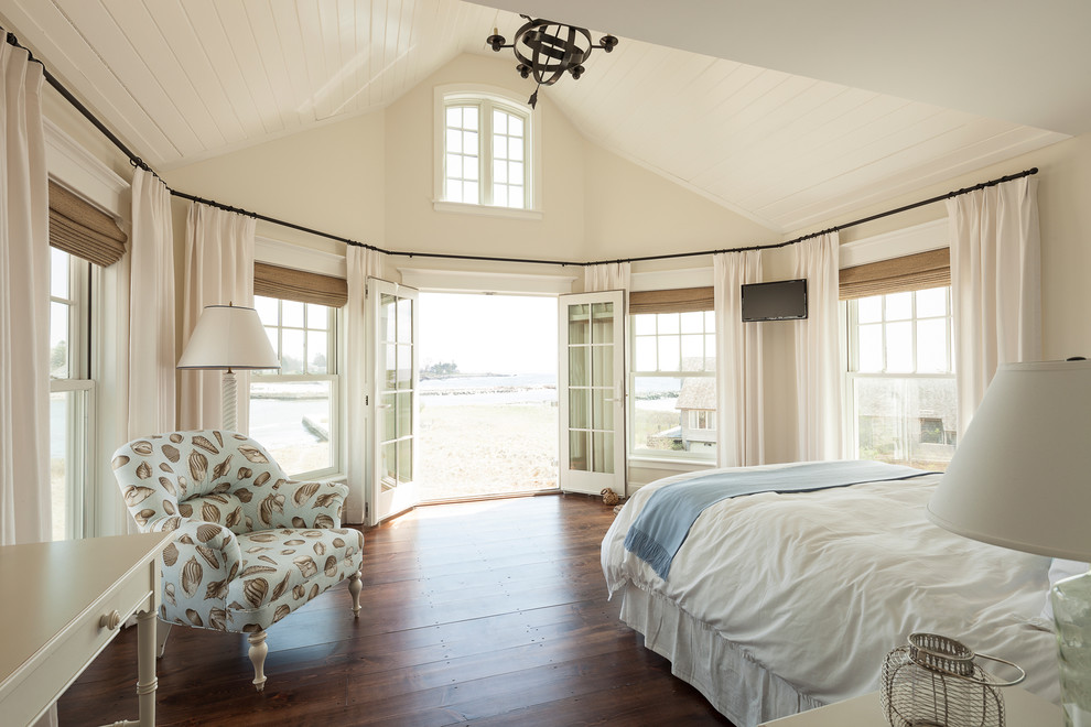 Photo of a beach style bedroom in Portland Maine with beige walls, dark hardwood floors and brown floor.