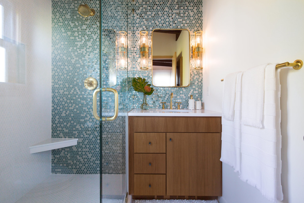 Design ideas for a mid-sized midcentury master bathroom in Seattle with flat-panel cabinets, light wood cabinets, a corner shower, a bidet, blue tile, glass tile, white walls, light hardwood floors, a wall-mount sink, quartzite benchtops, white floor and a hinged shower door.