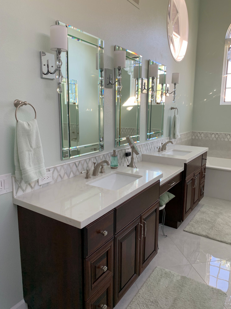 Large traditional master bathroom in Los Angeles with raised-panel cabinets, dark wood cabinets, a freestanding tub, a curbless shower, a two-piece toilet, green tile, porcelain tile, green walls, porcelain floors, an undermount sink, engineered quartz benchtops, beige floor, a hinged shower door, white benchtops, a double vanity, a built-in vanity, vaulted and decorative wall panelling.