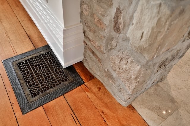 Example of a mid-sized mountain style medium tone wood floor and brown floor great room design in Toronto with white walls, a standard fireplace and a wood fireplace surround