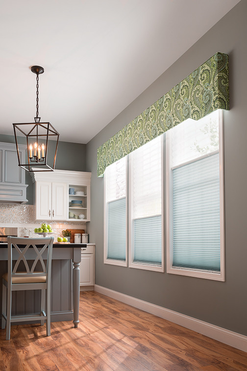 Inspiration for a mid-sized transitional single-wall medium tone wood floor and brown floor eat-in kitchen remodel with raised-panel cabinets, white cabinets, metallic backsplash, glass tile backsplash and an island