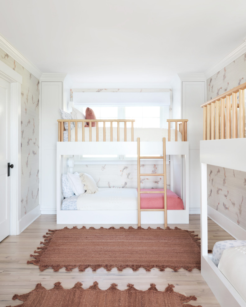 This is an example of a mid-sized beach style kids' bedroom for kids 4-10 years old and girls in New York with multi-coloured walls, light hardwood floors and brown floor.