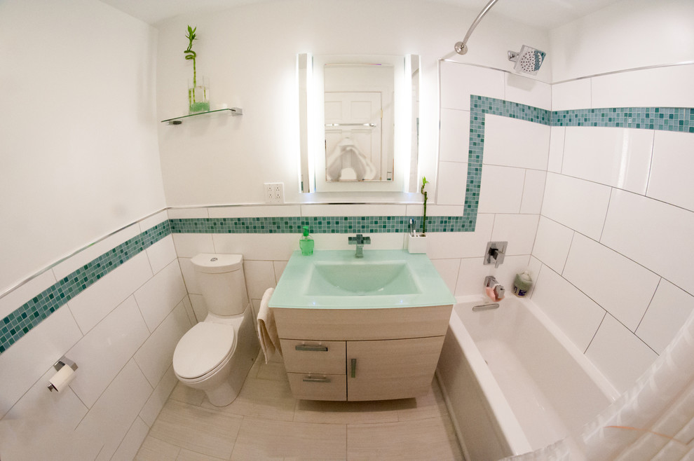 This is an example of a small modern master bathroom in Other with a drop-in sink, flat-panel cabinets, white cabinets, glass benchtops, a drop-in tub, a shower/bathtub combo, a two-piece toilet, white tile, porcelain tile, white walls and porcelain floors.