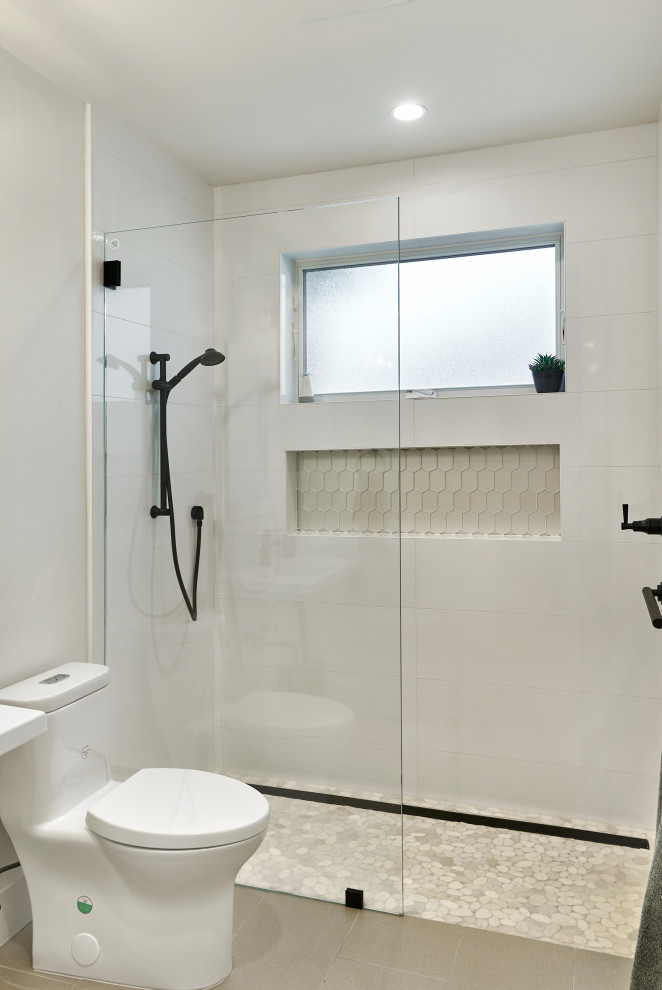 Design ideas for a mid-sized arts and crafts 3/4 bathroom in San Francisco with an open shower, a one-piece toilet, white tile, porcelain tile, white walls, porcelain floors, a wall-mount sink, grey floor, a hinged shower door, a niche, a single vanity and a floating vanity.